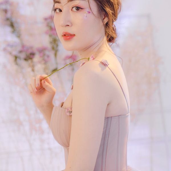 Person smiling gently while looking at a beautiful sunset over mountains.